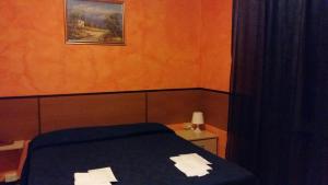 a bed in a room with a painting on the wall at Hotel Violetta in Parma