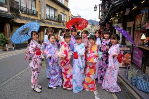 丰冈市森津屋的一群身穿和服、手持雨伞的年轻女孩