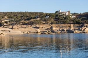 a view of a body of water with a rocky shore at Casa Rural Marchena in Navahermosa
