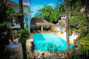 una imagen de una piscina frente a una casa en Hotel Solar das Águas Cantantes, en Ubatuba