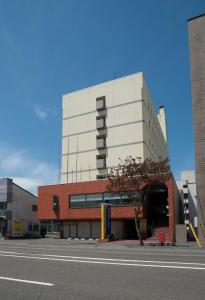 a tall white building on a city street at Smile Hotel Tomakomai in Tomakomai