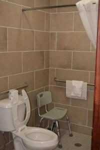 uma casa de banho com um WC e uma cadeira em Days Inn by Wyndham Jacksonville NC em Jacksonville