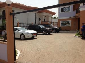 dois carros estacionados numa entrada de uma casa em Bastos'Appart YAOUNDE em Iaundé