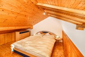 a bed in a room with wooden ceilings at Apartmani Amila-Pisak in Pisak
