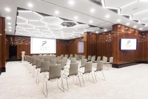a conference room with a row of chairs and a screen at Hotel Platinia in Cluj-Napoca