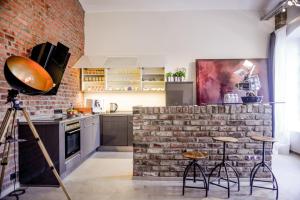 una cocina con una pared de ladrillo y algunos taburetes en Carl-Kaiser-Loft I, en Solingen