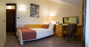 a bedroom with a bed and a chair at Hotel Bouton d'Or - Courmayeur in Courmayeur