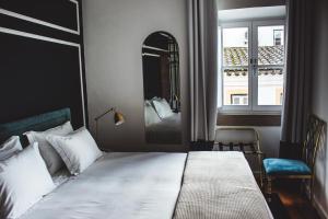 a bedroom with a bed and a mirror and a window at Valeriana Exclusive GuestHouse in Évora