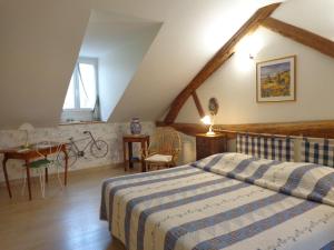 a bedroom with a bed and a table and a chair at B&B Les Cistelles in Saint-Nicolas-lès-Cîteaux