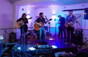 een groep mensen die instrumenten bespelen in een ruimte bij The Lion Hotel in Belper