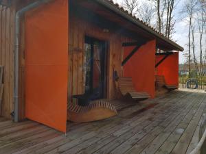 an outside view of a wooden house with orange walls at Au Bois Flotté in Hourtin