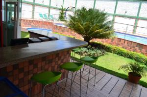 a bar with green stools in a building at Gran Hotel Internacional Sanbara in Arauca