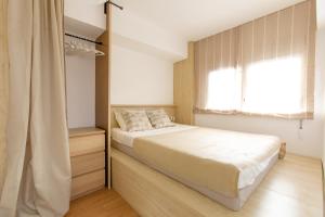a small bedroom with a bed and a window at Miro in El Campello
