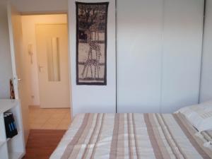 モンペリエにあるLUMINEUX avec vue , proche CENTRE historiqueのベッドルーム1室(ベッド1台付)が備わります。壁に絵が飾られています。