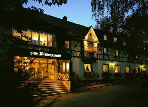 a lit up building with a sign in front of it at Hotel Wiesengrund in Lindenfels