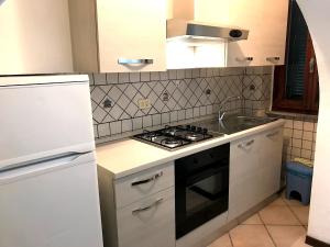 a kitchen with a stove and a sink at Appartamento Lungomare in Marciana Marina
