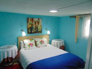 メディナ・シドニアにあるTranquila Casa de Campo cerca de Chiclanaの青いベッドルーム(ベッド1台、テーブル2台付)