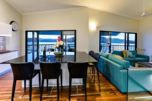 a living room with a blue couch and a table at Casuarina 16 - 3 Bedroom House With 180 Degree Ocean Views, Buggy & Valet Service in Hamilton Island