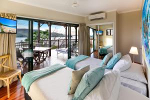 Dos camas en una habitación con balcón. en Casuarina 16 - 3 Bedroom House With 180 Degree Ocean Views, Buggy & Valet Service, en Hamilton Island