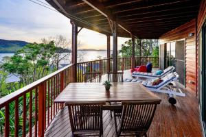 a wooden deck with a table and chairs on it at Casuarina 16 - 3 Bedroom House With 180 Degree Ocean Views, Buggy & Valet Service in Hamilton Island