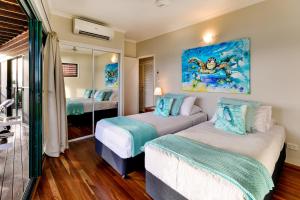 Un dormitorio con dos camas y un cuadro en la pared. en Casuarina 16 - 3 Bedroom House With 180 Degree Ocean Views, Buggy & Valet Service, en Hamilton Island 24 fotos más