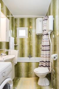 łazienka z toaletą, umywalką i wanną w obiekcie Holiday house "Kale" w mieście Drače