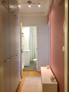a bathroom with pink walls and a bathroom with a tub at Ullanlinna Studio in Helsinki