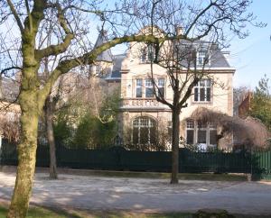 una casa grande con una valla delante en Villa Camoufle en Metz