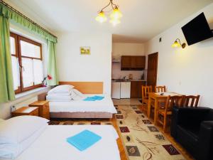 pokój hotelowy z 2 łóżkami i stołem w obiekcie Willa Dutka w mieście Szczawnica