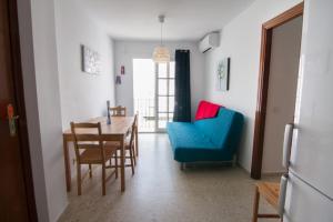 アルガロボ・コスタにあるEjuind Apartment Playaのリビングルーム(テーブル、青い椅子付)