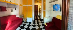 um quarto com um sofá vermelho e um piso xadrez em Mono Logge em Marciana Marina
