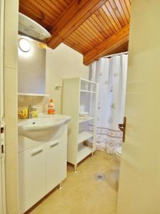 a bathroom with a sink and a shower curtain at Apartments Ljubica in Barbat na Rabu
