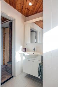 a white bathroom with a sink and a door at Engelbarn in Engelbert