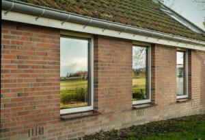 een bakstenen gebouw met drie ramen en een veld bij Engelbarn in Engelbert