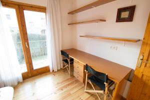 アルプにあるCasa amb jardí Alpの木製デスク、窓が備わる客室です。