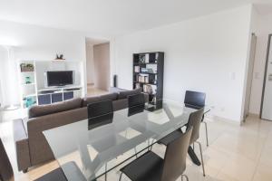 a dining table and chairs in a living room at modern flat in Estoril