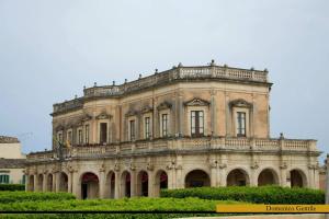 a large stone building with many windows at Sweet home in Noto