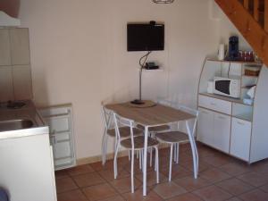 a kitchen with a table and chairs and a microwave at Sente des Vignes in Hauteville