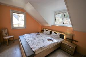 a bedroom with a bed and two windows at Beilsteiner Ferienwohnungen in Beilstein