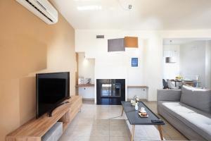 Dream Villa في Kambánion: غرفة معيشة مع أريكة وتلفزيون