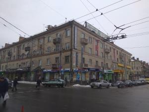un gran edificio en una calle de la ciudad con coches aparcados en Apartment on Sobornaya street en Rivne