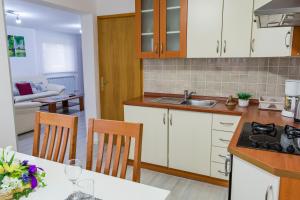 a kitchen with white cabinets and a table with chairs at Guesthouse Franjkovic in Seliste Dreznicko