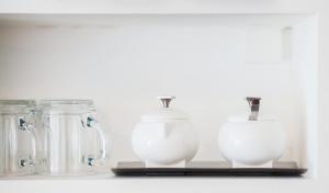 a shelf with four glass jars and a white jug at Charming 30m² border of MONTMARTRE in Paris