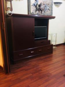 a flat screen tv sitting on a entertainment center at Divan Hotel Apartments in Beirut