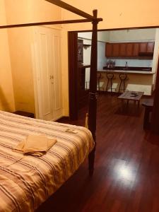 a bedroom with a bed and a kitchen in the background at Divan Hotel Apartments in Beirut