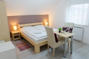a bedroom with a bed and a table and chairs at Guesthouse Franjkovic in Seliste Dreznicko