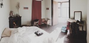 a bedroom with a white bed and a fireplace at Refugi Quatre Cases in Clot del Moro