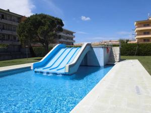 eine Rutsche in einem Pool mit blauem Wasser in der Unterkunft Sistach Rentals Apartments Blau Park 310 & 311 in L'Estartit