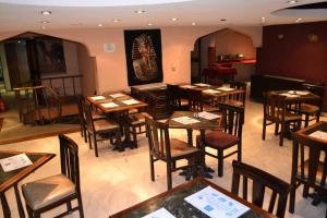 a restaurant with wooden tables and chairs in a room at Kaoud Sporting Hotel in Alexandria