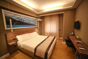 ein Hotelzimmer mit Bett und Schreibtisch in der Unterkunft 7th Floor Suite in Neapel